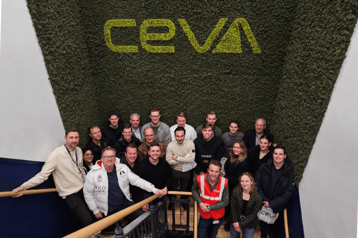 Groep mensen voor groene wand met het logo van CEVA