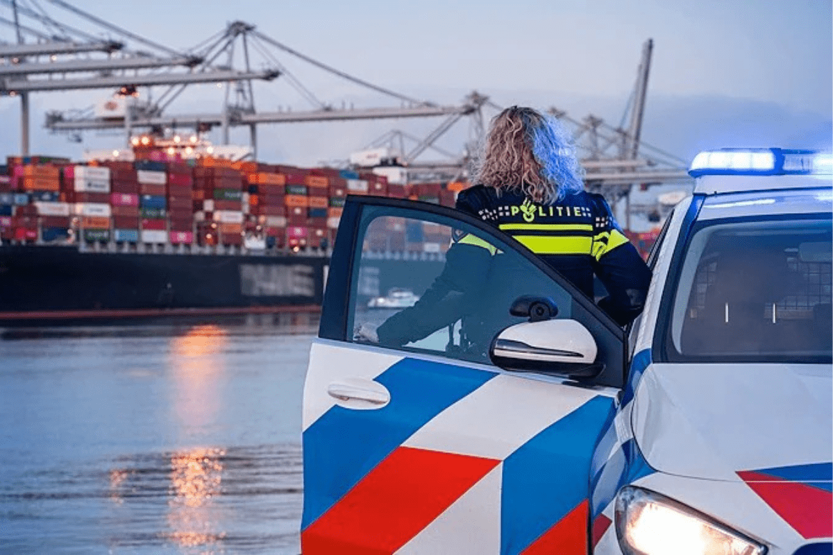 Politie in de haven voor een schip met containers