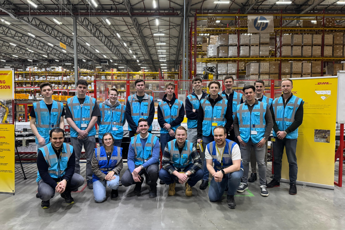 Een groep mensen poseren op de foto in het magazijn van DHL
