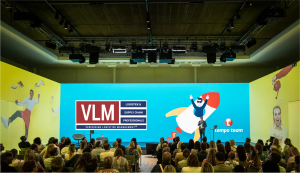 A large room with the logo of Tempo Team with a rocket and the logo of VLM