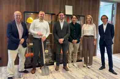 Een groep mensen poseert voor een vitrinekast bij het Ministerie van Infrastructuur en Waterstaat